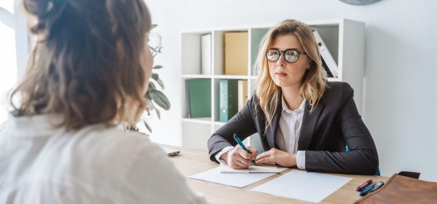 Young female candidate is interviewed by employer businesswoman
